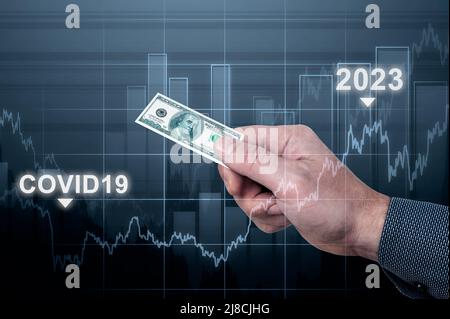 inflation. man holds small one hundred dollar bill in his hand. economic crisis caused by covid19 pandemic. symbol of inflation, rising consumer price Stock Photo