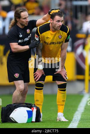 15 May 2022, Saxony, Dresden: Soccer: 2. Bundesliga, SG Dynamo Dresden - FC Erzgebirge Aue, Matchday 34, Rudolf-Harbig-Stadion. Dynamo's Michael Sollbauer (r) gets his head cooled by physiotherapist Tobias Lange after a foul. Photo: Robert Michael/dpa - IMPORTANT NOTE: In accordance with the requirements of the DFL Deutsche Fußball Liga and the DFB Deutscher Fußball-Bund, it is prohibited to use or have used photographs taken in the stadium and/or of the match in the form of sequence pictures and/or video-like photo series.