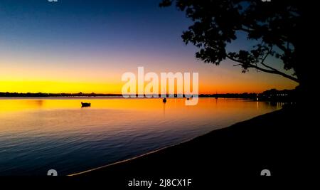 Sailboats in the sunset - view toward Bribie Island Bridge over the Pumicestone Passage with Glasshouse mountains on horizon Stock Photo