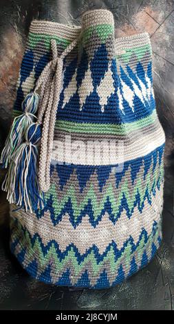Handmade bags. Knitted from colored threads. Volumetric and comfortable to wear with a long handle. Crochet and knitting. Stock Photo