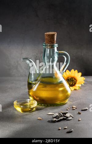 Sunflower oil on dark concrete background with shadows . Vertical format. Stock Photo