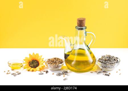 Sunflower oil and sunflower seeds on white and yellow background with copyspace. Stock Photo