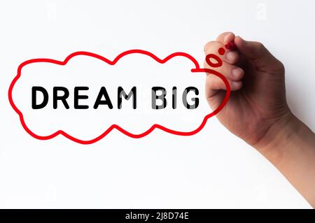 Hand writing Dream Big in cloud bubble on transparent wipe board. Stock Photo
