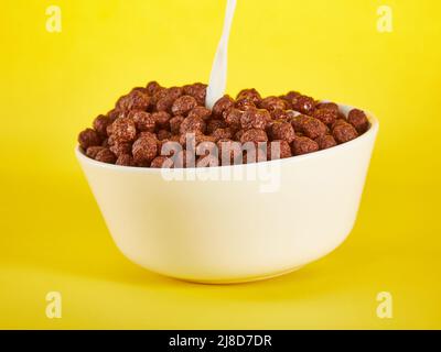 Chocolate Corn balls in bowl over yellow background Stock Photo