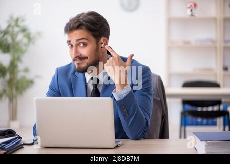 Deaf businessman employee using hearing aid in the office Stock Photo