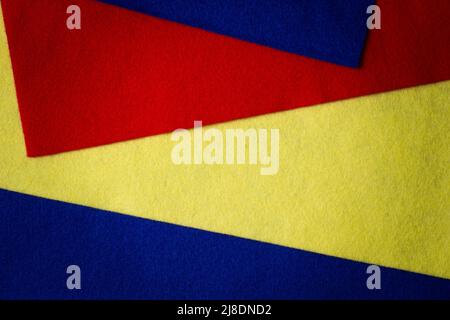 Abstract colorful geometric felt texture background. Bright yellow, blue, red colors felt textile for craft. Top view, flat lay Stock Photo