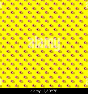 pattern made of Freshly baked donuts  with icing and sprinkles for breakfast on a yellow background . Sweet background. Bakery, baking concept. Stock Photo