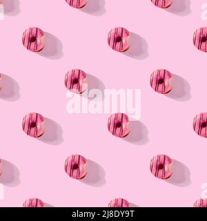 pattern made of Freshly baked donuts for breakfast on a pink background . Sweet background. Bakery, baking concept. Stock Photo
