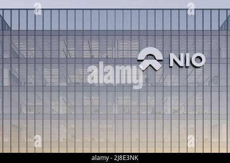 Shanghai, China. May 2, 2022. Editorial Use Only, 3D CGI. NIO Company Signage Logo on Top of Glass Building. Workplace Electric Vehicles Automaker Off Stock Photo