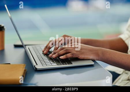 Side view closeup of black businesswoman typing at laptop keyboard while working, copy space Stock Photo