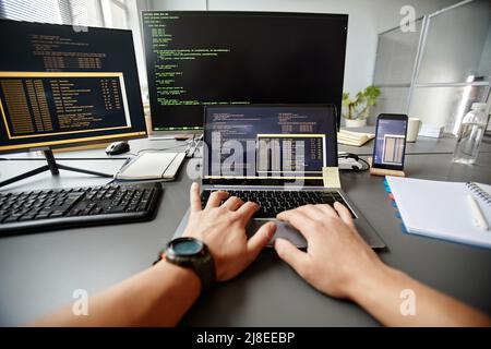 POV of QA engineer typing on keyboard while using computer at workplace in office, copy space Stock Photo