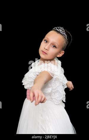 Girl ballet dancer looking at camera, dancing on black background in studio. Part of photo series Stock Photo