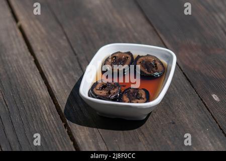 Selective focus down view of plate of walnut jam on wooden table. Stock Photo