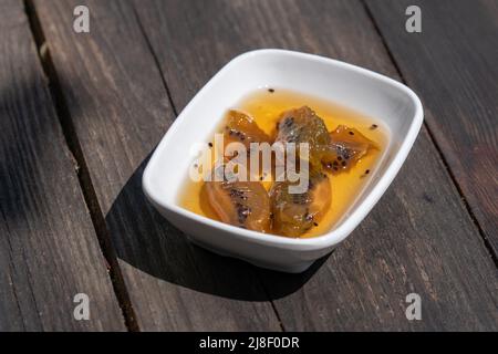 Selective focus down view of plate of kiwi jam on wooden table. Stock Photo