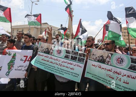 Gaza, Palestine. 15th May, 2022. Palestinians hold banners and flags during a march to commemorate the 74th anniversary of the 'Nakba' in Gaza City. The anniversary of the Nakba falls on May 15 of every year, the day of the establishment of the State of Israel in 1948. Credit: SOPA Images Limited/Alamy Live News Stock Photo