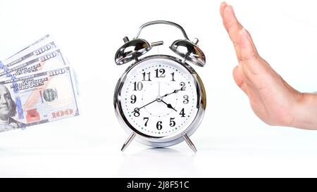 Retro alarm clock placed in the middle of a female hand and dollar cash on white background. Stock Photo