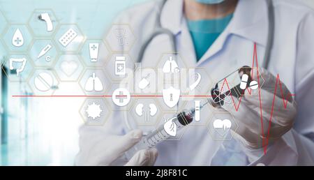Medicine doctor with stethoscope in hand hold syringe icon medical network connection on virtual screen interface. Modern medical technology and innov Stock Photo