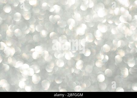 Abstract silver bokeh background, defocused blurry sparkles. Beautiful shiny background with highlights and sparkles on a silvery background. Defocus. Stock Photo