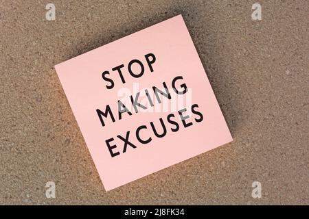 Stop making excuses text on sticky note against brown paper background. Motivational phrase and encouraging action. Stock Photo