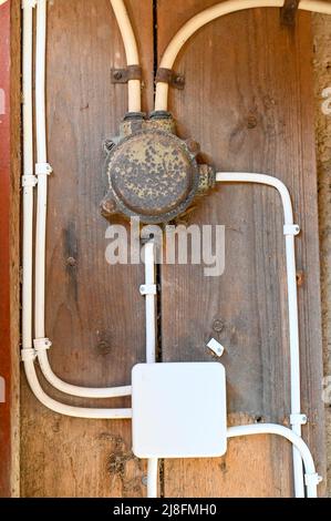 new and old distribution boxes for electricity in barn Stock Photo