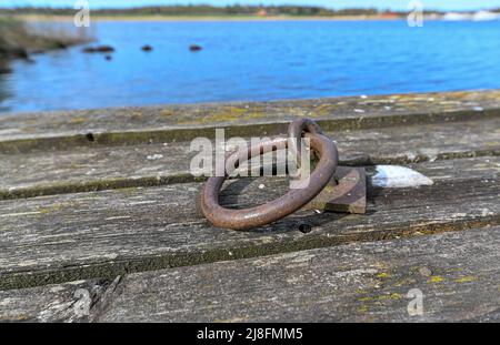 old jetty with round rusty mooring ring Stock Photo