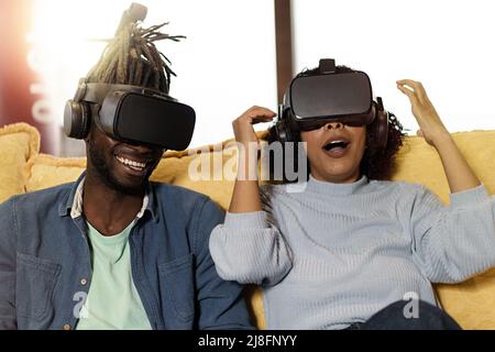 Amazed couple of multi-ethnic young people having fun playing video games with 360 vr 3d googles - lifestyle concept of friends having fun with tech g Stock Photo