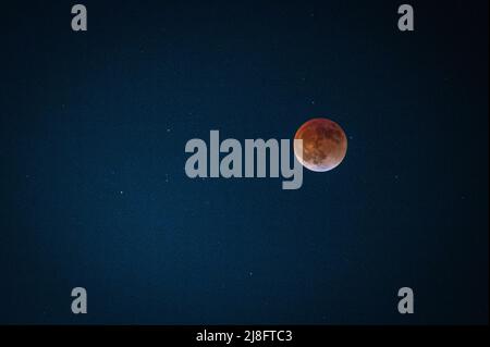 Austin, Texas, USA. 15 May, 2022. The Super Flower Blood Moon eclipse of May 2022 has happened. This total lunar eclipse was visible in Austin, Texas starting about 10:30PM and continuing on through midnight. The shadow of the earth gives it its red colour. It is called the Flower moon because of the abundance of flowers growing in May. Credit: Sidney Bruere/Ģ����ý Live News Stock Photo