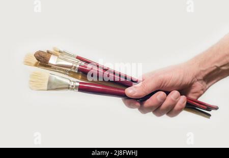 hand holds fresh synthetic brushes on white Stock Photo