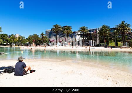 Brisbane Australia / A man enjoys the sunshine at Streets Beach an urban man made swimming beach. Stock Photo