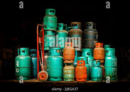 Gas canisters stacked together in a doorway with dark background Stock Photo