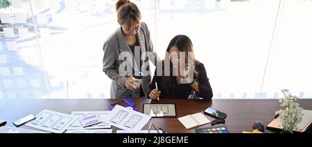 Creative women drawing and planning website interface on digital tablet. Stock Photo