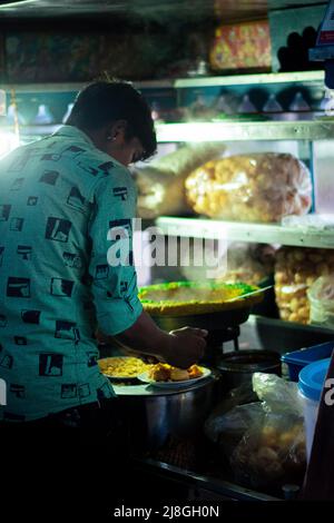 A picture of a street vendor selling bhel puri in Indian streets (Bhelpuri is a savoury snack originating from India, and is also a type of chaat) Stock Photo