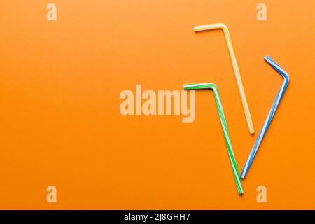 Drinking straws for party on Colored background. Top view of colorful plastic disposable straws for summer cocktails. different straws for juice with Stock Photo
