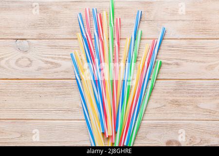 many multi-colored plastic tubes for cocktail on Colored background, top view. Stock Photo