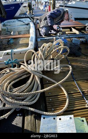 solitary man working on mooring pontoon at yacht club Stock Photo