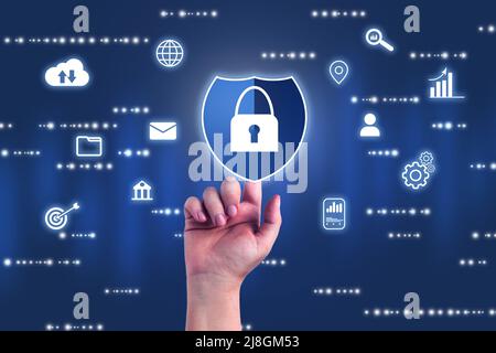 Hand touching blue lock shield with digital security interface. Internet of things. Cybersecurity concept. Icon shield with a lock symbol. Stock Photo