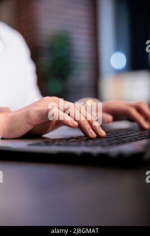 Close up of financial company employee analyzing accounting data and project state while sitting at desk. Financial advisor in office workspace developing marketing strategy on computer laptop. Stock Photo