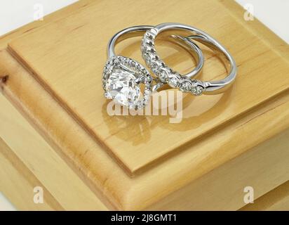 Engagement Ring and Diamond Wedding Ring Set on Wooden Ring Box Stock Photo