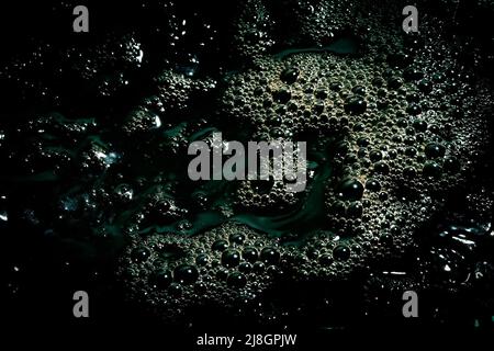 Black water surface with bubbles. Dark liquid background. Stock Photo