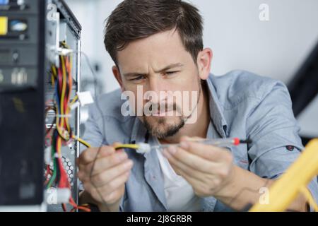a male worker is fitting computer cables Stock Photo