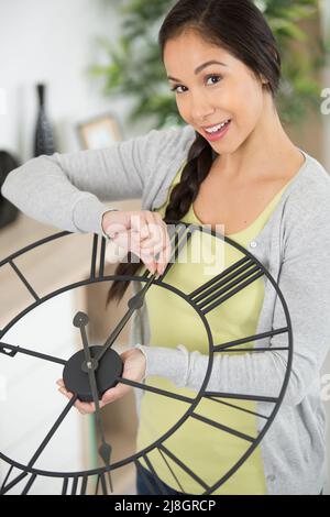 woman changing the time on a clock Stock Photo
