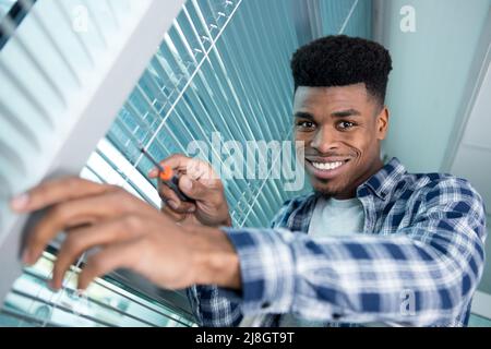 man is installing window blinds Stock Photo