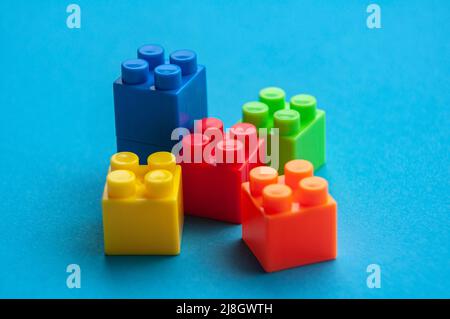 Plastic building blocks on blue background. Copy space. Stock Photo