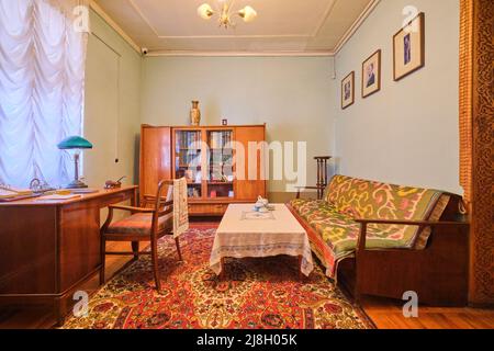 One of the writing offices, with desk, sofa and bookcase. At writer, poet, author, literary translator Garfur Gulom's home, house museum in Tashkent, Stock Photo