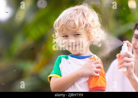 Mosquito on kids skin. Little boy attacked by mosquitoes in tropical forest. Insect repellent. Malaria and dengue fever prevention. Stock Photo