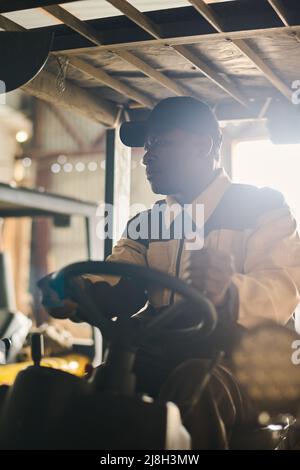 Male warehouse worker driving and operating on forklift truck for transfer products or parcel goods in warehouse Stock Photo