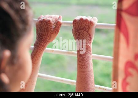 sad child girl looking through window  Stock Photo
