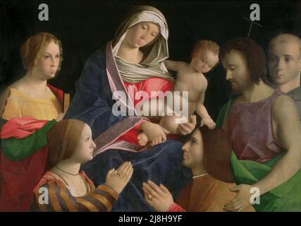 Madonna and Child with the Infant St. John the Baptist and St. Lawrence and Angels, 1629 by Strozzi, Bernardo (1581-1644); 315x193 cm; Chiesa dei Sordomuti, Genoa, Italy; Italian,  out of copyright. Stock Photo