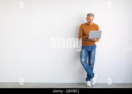 Confident mature man using laptop at home Stock Photo