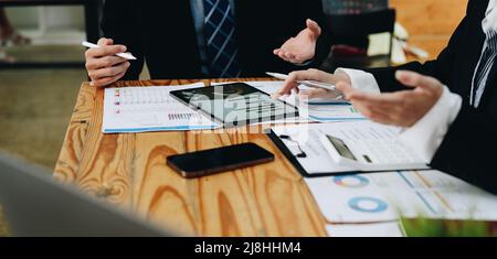 Close up diverse colleagues working on project together, working with legal documents, financial report with statistics, employees engaged in teamwork Stock Photo